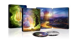A collectible steelbook case for the musical 'Wicked' featuring colorful artwork on the cover and interior, with two discs on the bottom.